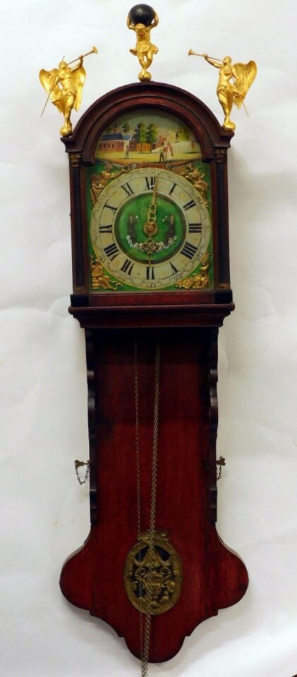 Continental Wall Clock by Unknown Artist. 19th c. Walnut case with figural finials of angels and Atlas. Village scene face.